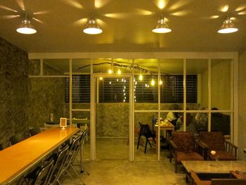 Empty chairs and tables in illuminated restaurant