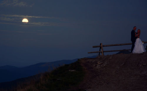 People on mountain against sky at dusk