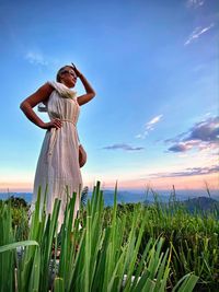 Woman standing on field against sky