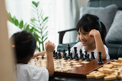 Side view of a smiling girl playing on table