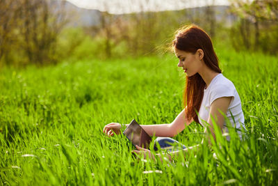 Portrait of young woman sitting on field