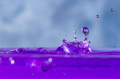 Close-up of water splashing against purple wall