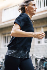 Low angle view of woman jogging while listening music