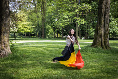 Portrait of a girl with a belgian flag in the park.