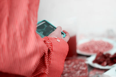 Close-up of man holding mobile phone on table