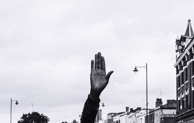 Low angle view of hand against sky