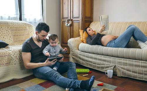 Rear view of friends sitting on sofa