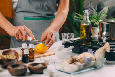 Woman cutting lemon for homemade soap