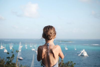 Rear view of woman looking at sea against sky