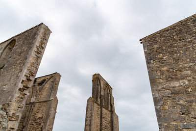 Low angle view of old building against cloudy sky