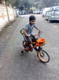 Full length of man riding bicycle on street