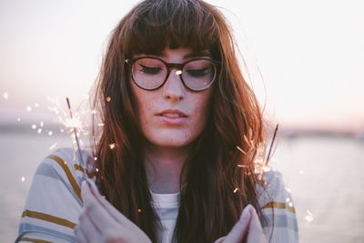 Portrait of beautiful young woman against sky