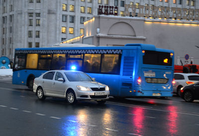 Cars on illuminated street in city at dusk