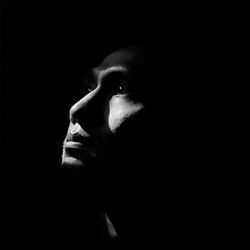 Portrait of young man against black background