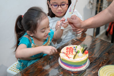 High angle view of mother and daughter on table