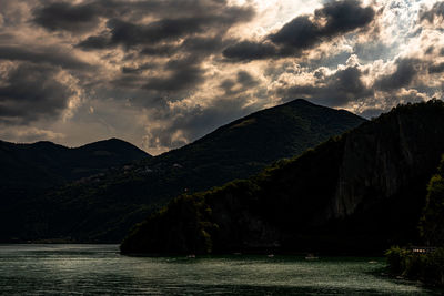 Scenic view of sea by mountains against sky