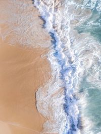 High angle view of waves rushing towards shore