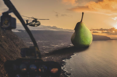 Close-up of apples on table by sea against sky