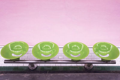Empty chairs at subway station against wall