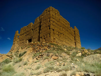 Low angle view of old building against blue sky