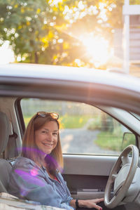 Portrait of a smiling young woman sitting in car