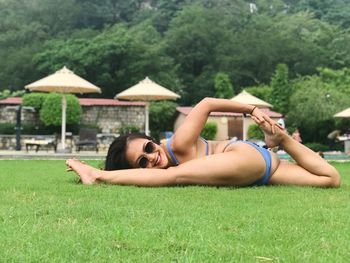 Portrait of woman in bikini exercising on field