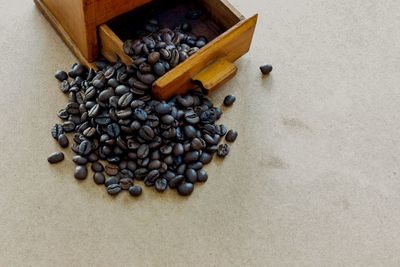 Close-up of coffee beans with grinder on table