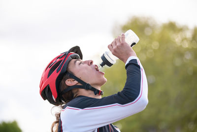 Side view of male athlete drinking water