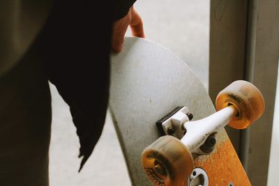 Midsection of woman holding skateboard