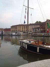 Boats moored at harbor against sky