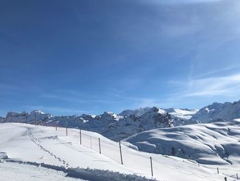 Snow covered mountain against blue sky