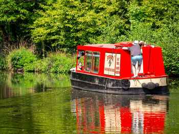 Red boat on lake against trees