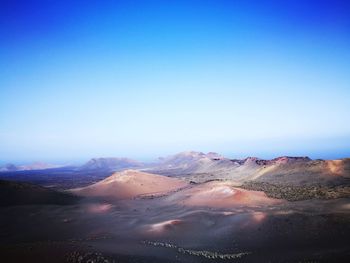 Scenic view of mountains against clear blue sky