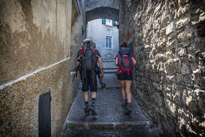 People walking in alley amidst buildings in city