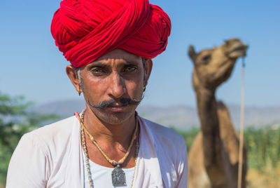 Close-up portrait of man wearing red turban 