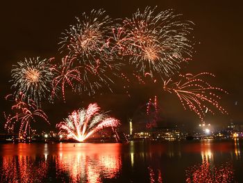 Firework display over river at night