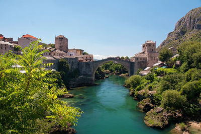 Arch bridge over river against sky