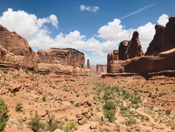 Rock formations on landscape against cloudy sky