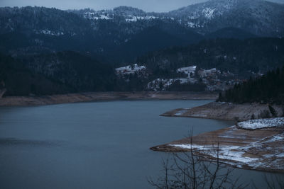 Scenic view of lake by mountains against sky