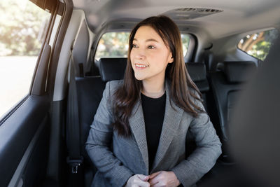 Portrait of young businesswoman in car