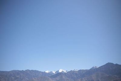 Scenic view of mountains against clear blue sky