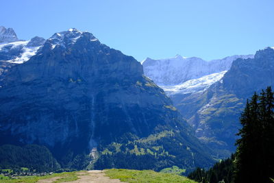 Scenic view of snowcapped mountains against clear blue sky