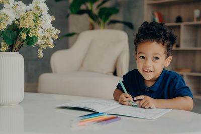 Portrait of boy sitting on sofa at home