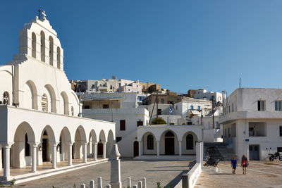 Buildings in city against clear blue sky