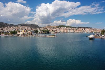 Aerial view of townscape by sea against sky