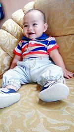 Portrait of cute boy sitting on bench