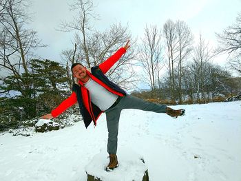 Woman with arms raised on field during winter