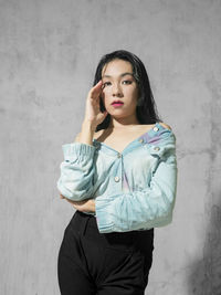 Young woman standing against wall