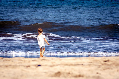 Side view of woman standing at beach