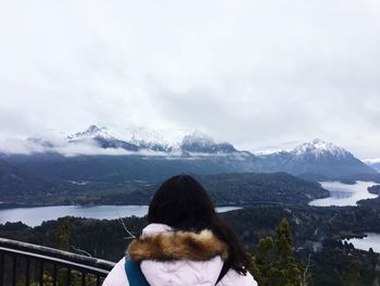 Rear view of woman looking at snowcapped mountain against sky